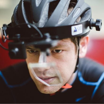 Man wearing bicycle helmet with various sensors and monitors attached